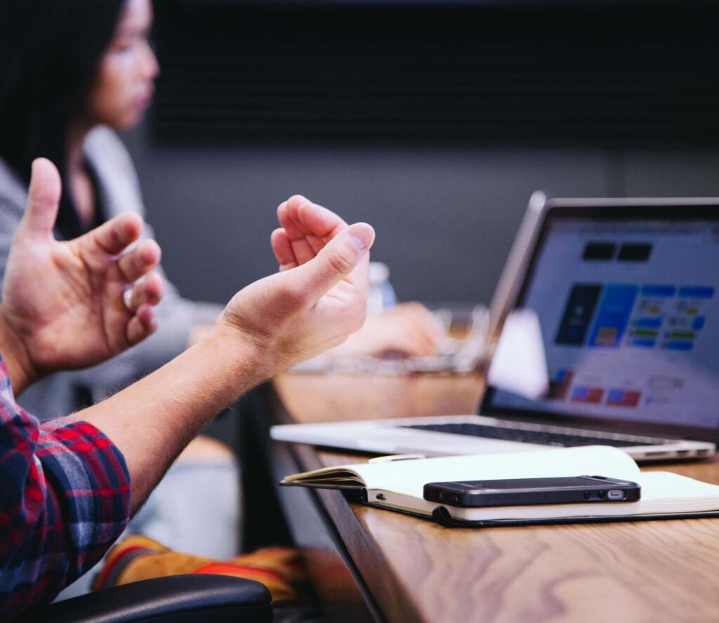 Man's hands in the air in front of a laptop